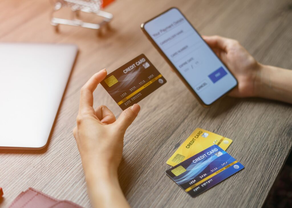 Hands Using Smartphone and Credit Card for Online Transaction